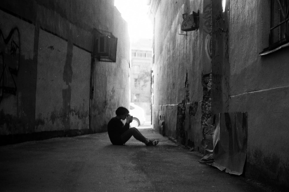 a man sitting on the side of a street