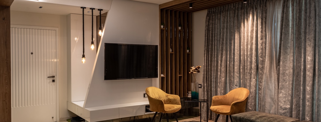 a living room with a tv and chairs