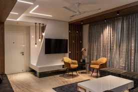 a living room with a tv and chairs