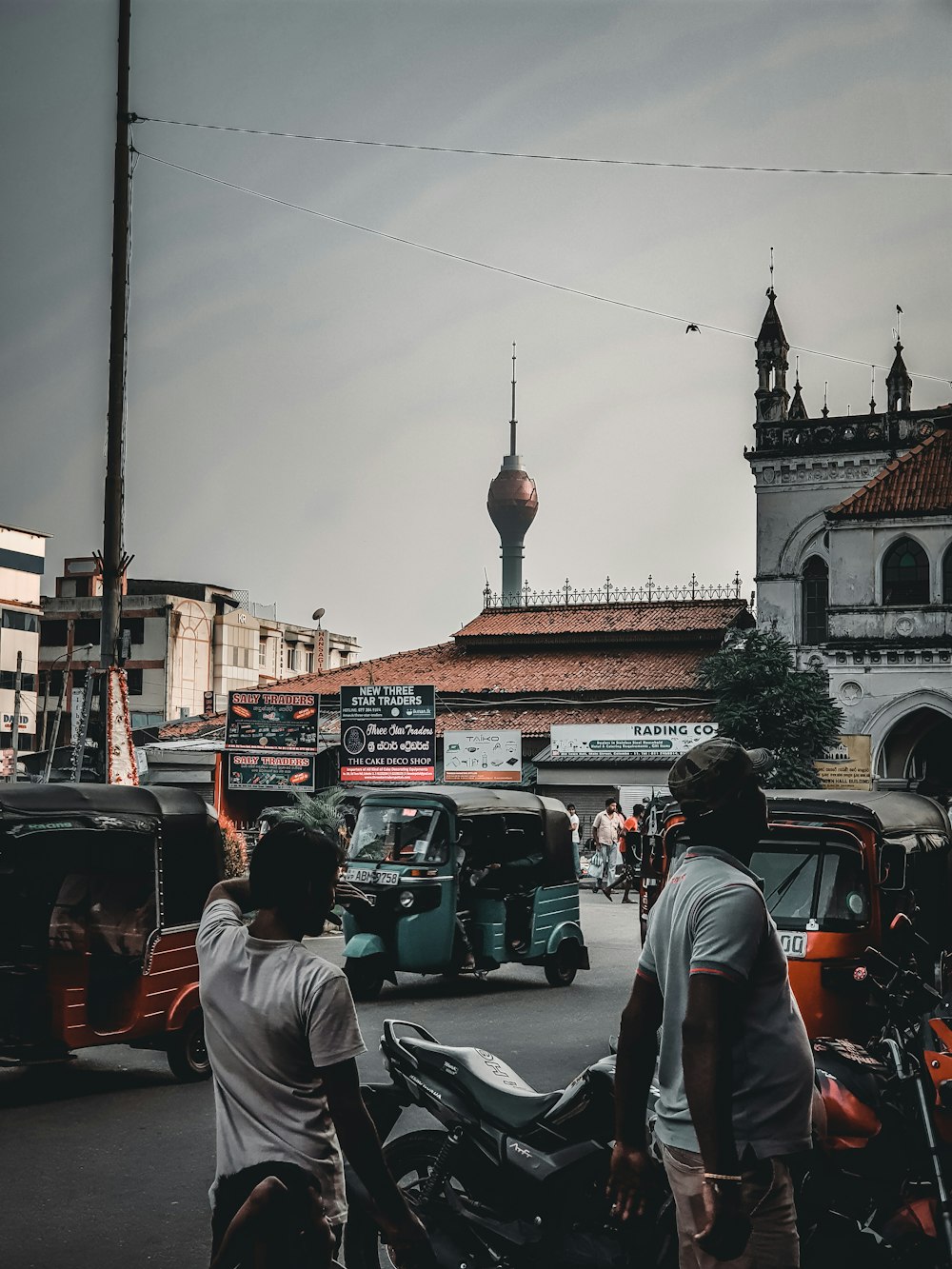 a group of people walking on a street with cars and buildings