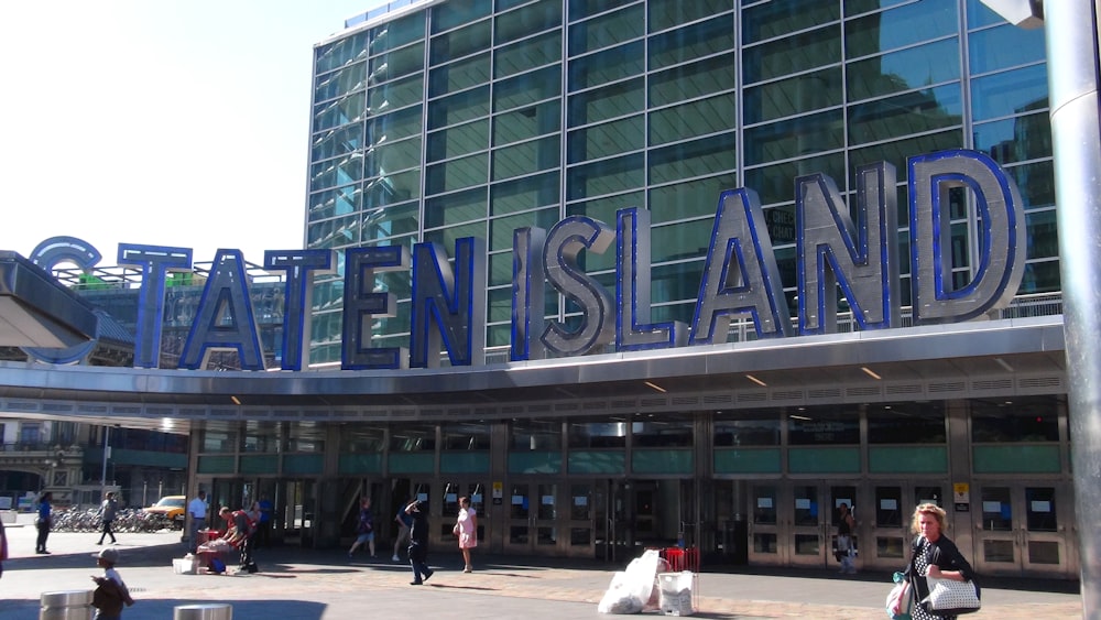 a large building with a sign on it with Staten Island Ferry in the background