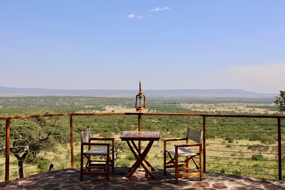 a table and chairs on a deck overlooking a field