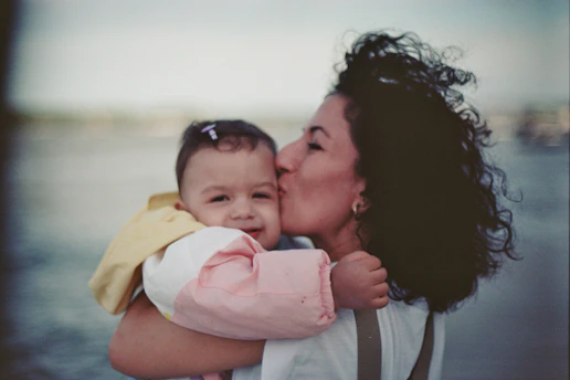 a person kissing a baby