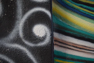 A close-up of Armin Mumper painting a vibrant wall mural blending multiple artistic styles.