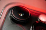 Close-up of a phone camera lens reflecting vibrant colors under smooth lighting.