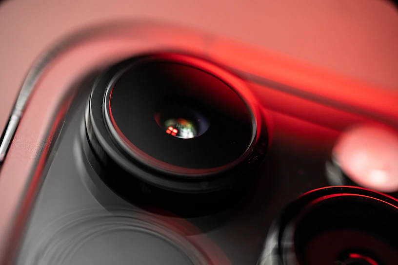 Close-up of a sleek smartphone showcasing an AI-powered camera lens under soft lighting.