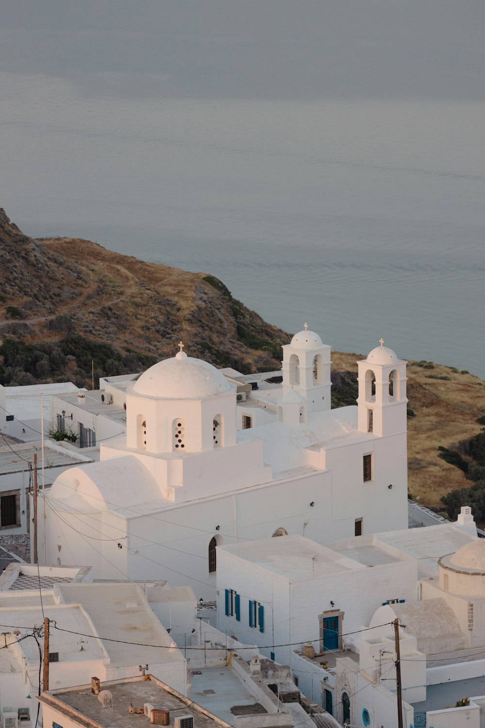 a white building with a hill in the background