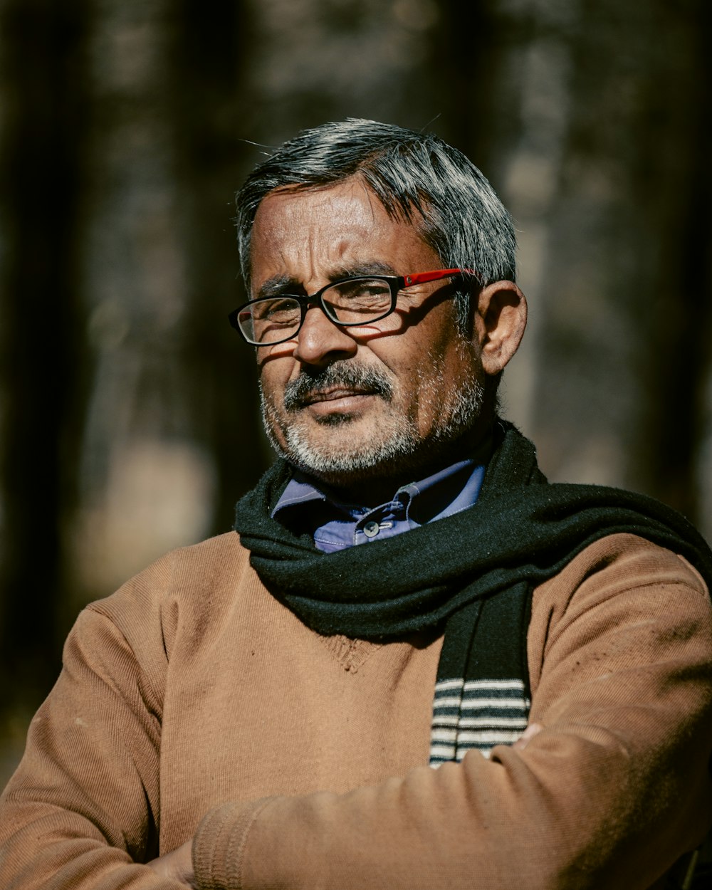 a man with glasses and a scarf