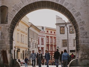 A docent leading a small group through historic streets lined with old brick buildings.