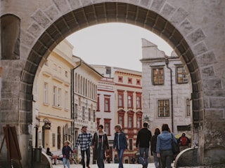 A group of travelers walking through a charming historic neighborhood with colorful buildings