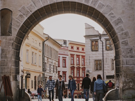 A group of travelers walking through a charming historic neighborhood with colorful buildings
