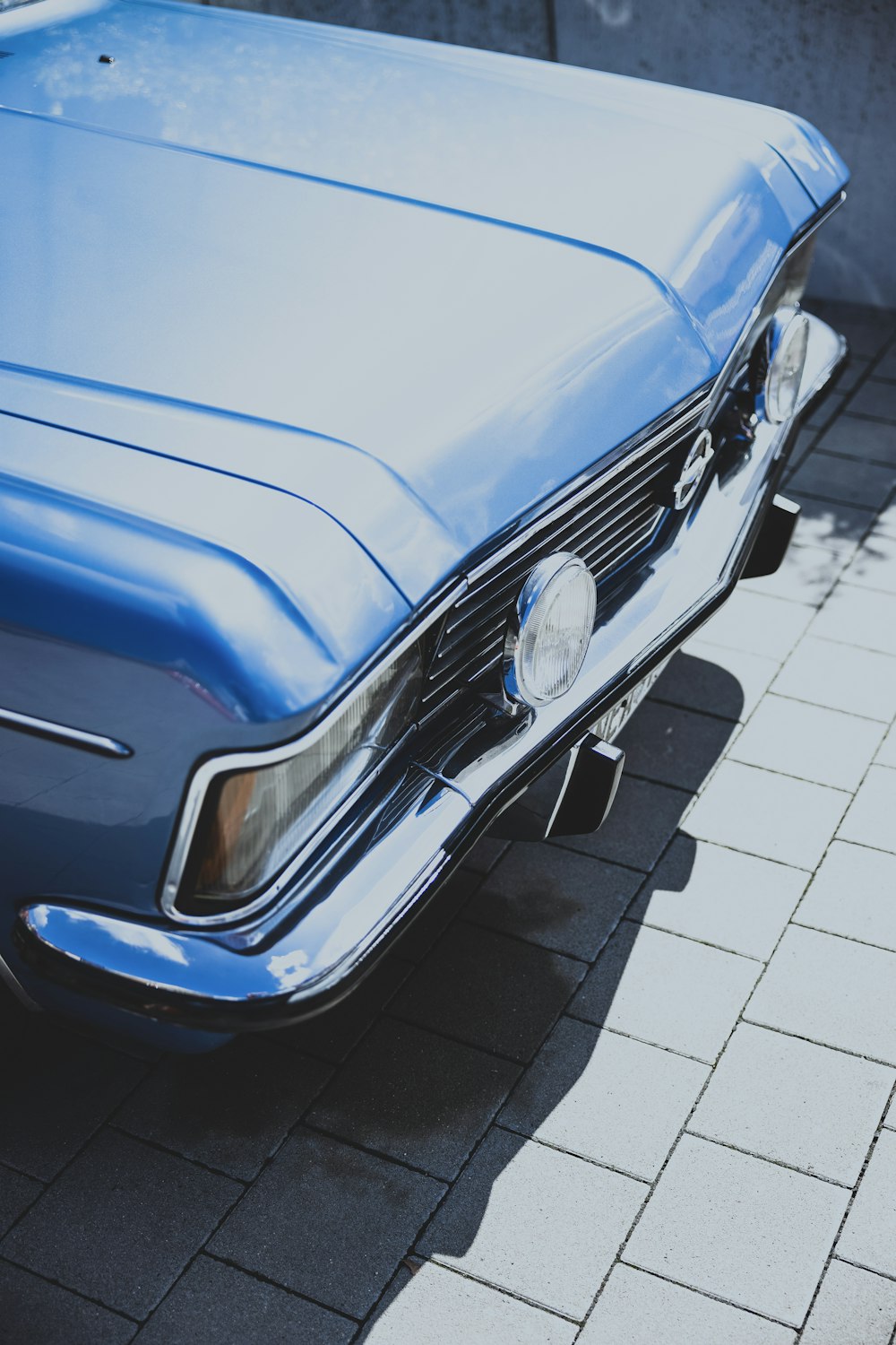 a blue car parked on a brick road