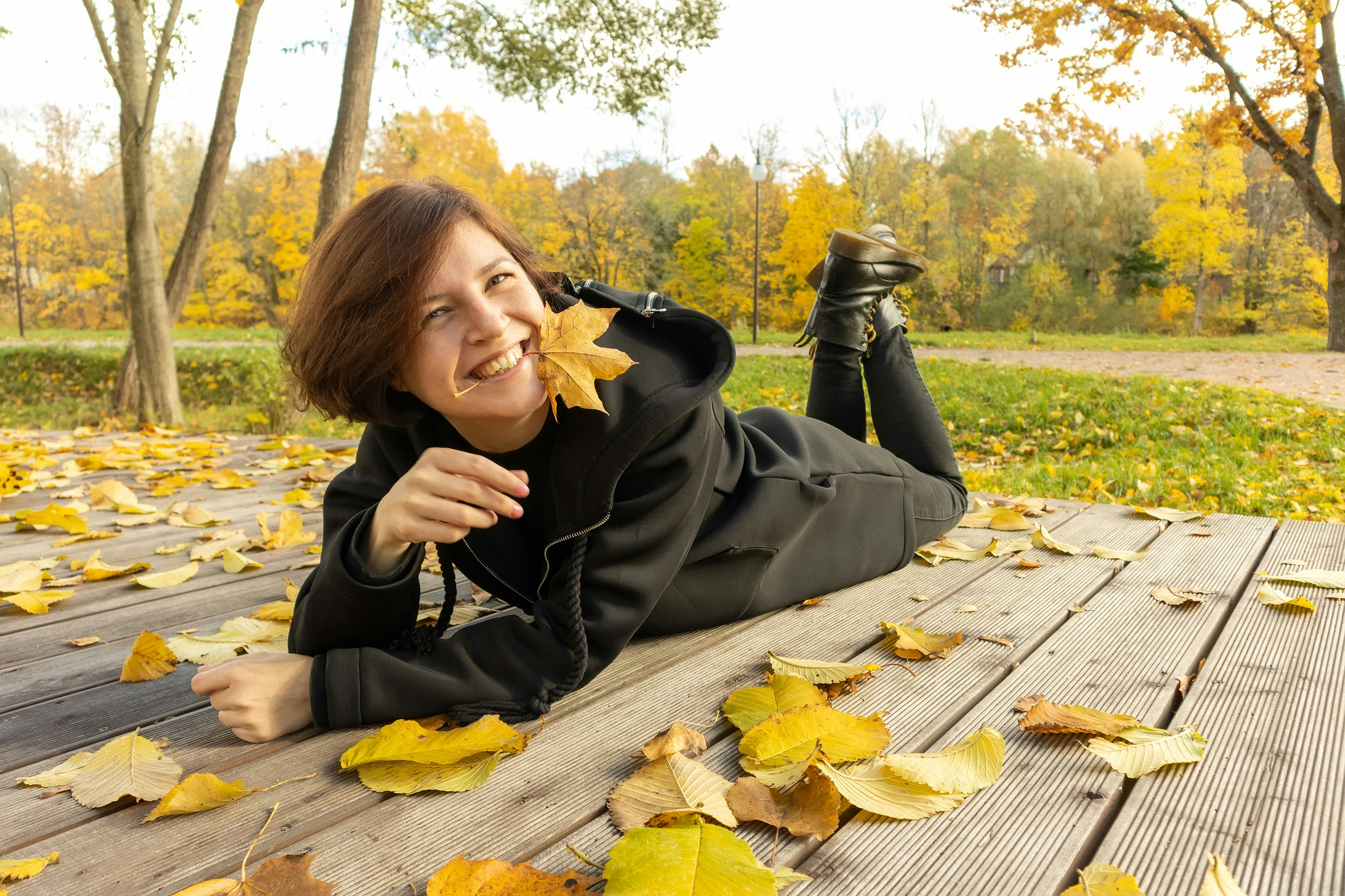 happy woman with yellow leaf in mouth for Rising Feminine EFT