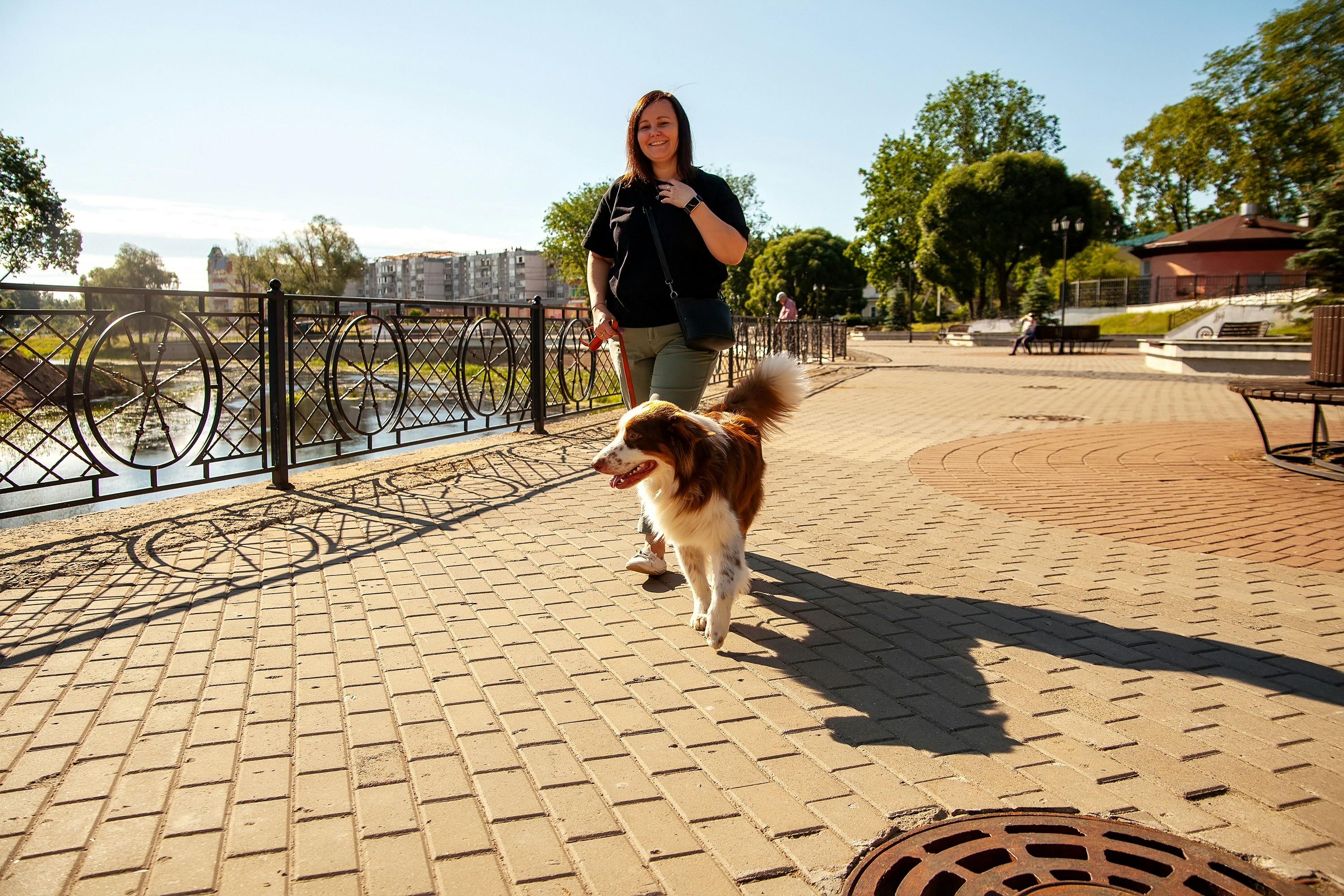 A resident happily walking their dog near a modern apartment building - pet friendly apartments near me