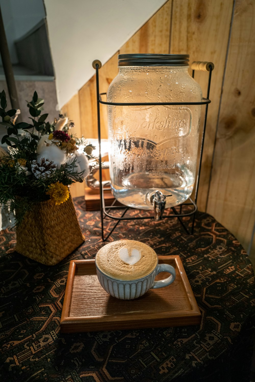 a glass coffee maker with a cup of coffee on a table