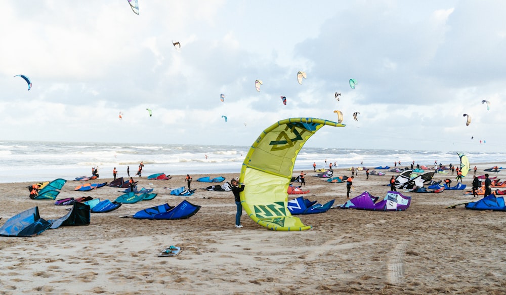 a group of people flying kites at the beach