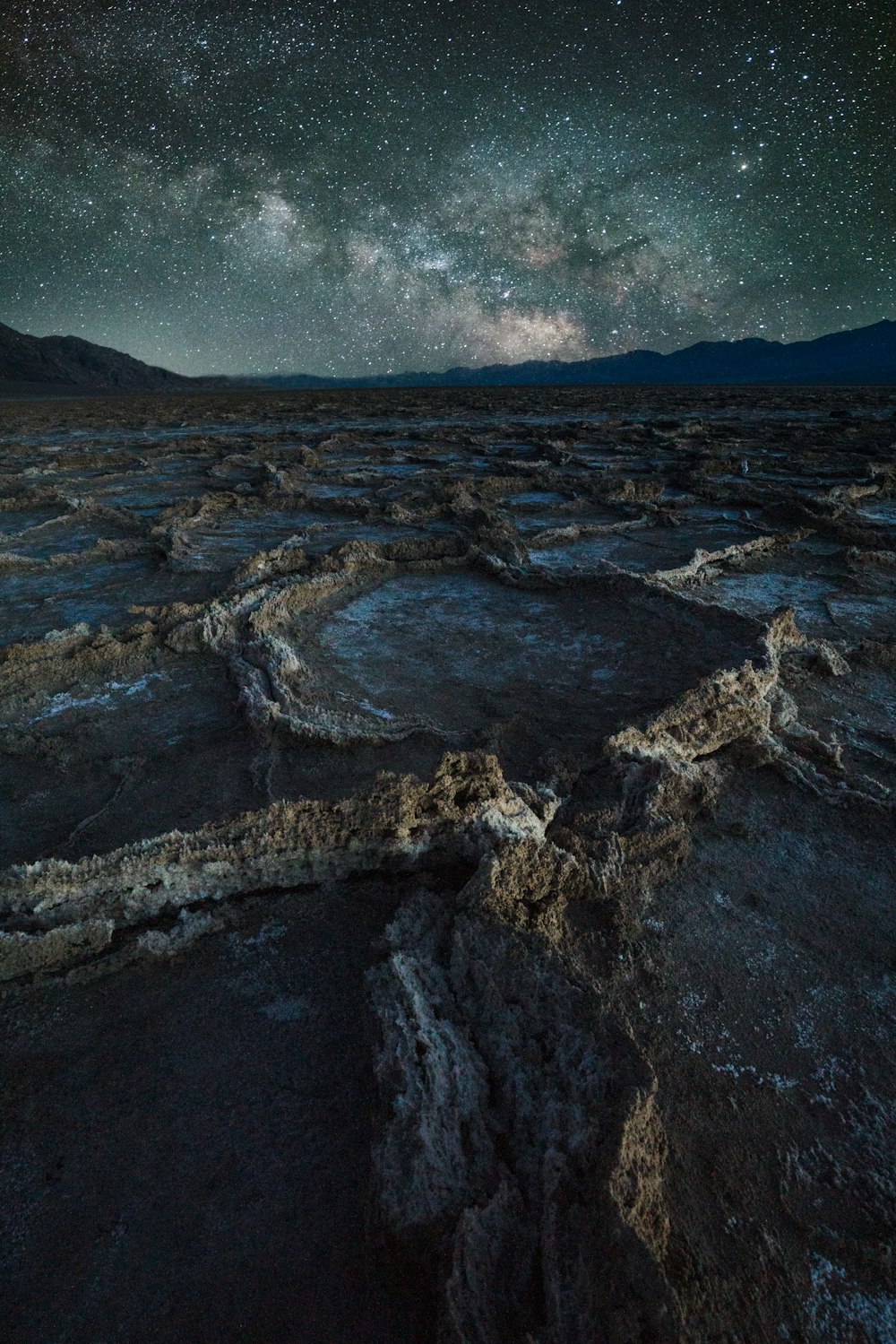 a rocky cliff with a starry sky above