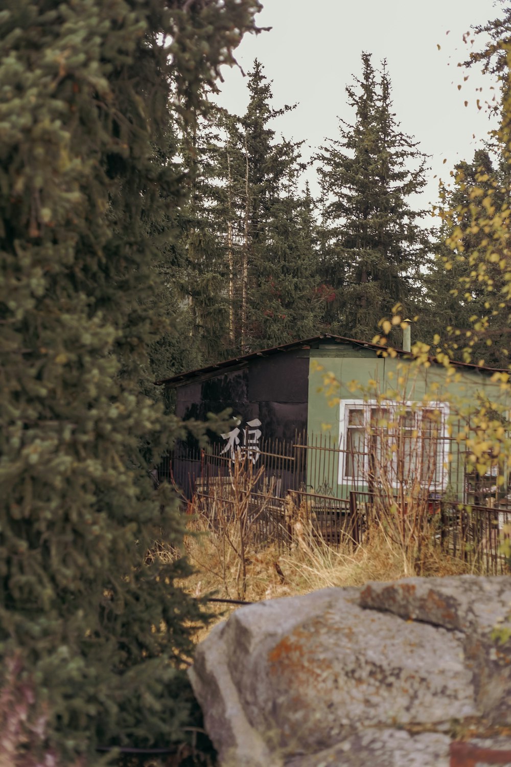 a house with a fence and trees around it