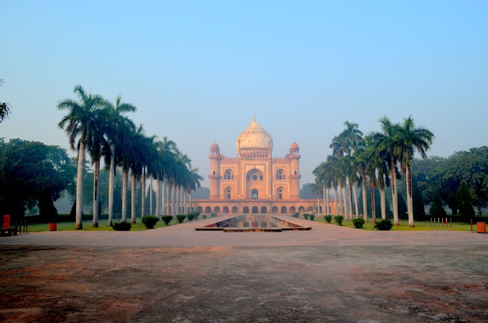 a building with a dome and palm trees in front of it