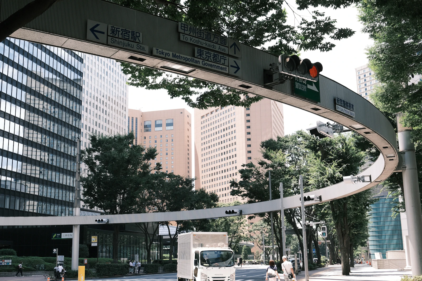 Road signs and traffic signals hang above a Tokyo street
