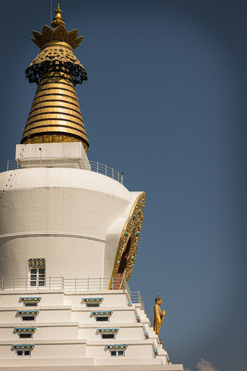 ein großer weißer Turm mit einer Statue auf der Spitze