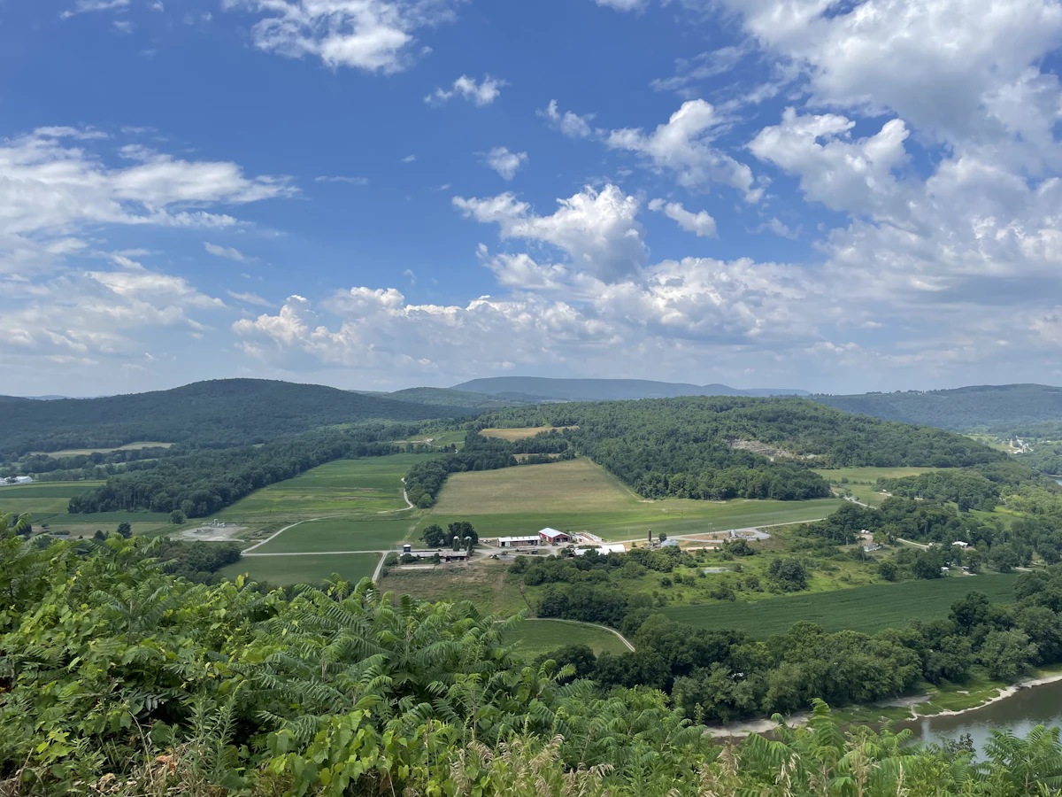 Green fields and wooded ridges under a blue sky, seen from a hilltop near Saxton in central Pennsylvania