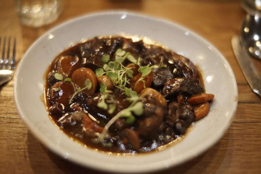 Bœuf bourguignon mijoté, sauce au vin rouge, champignons et carottes