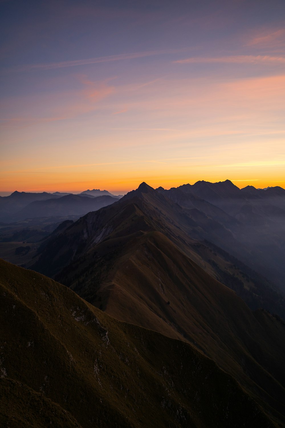 Une chaîne de montagnes avec un coucher de soleil
