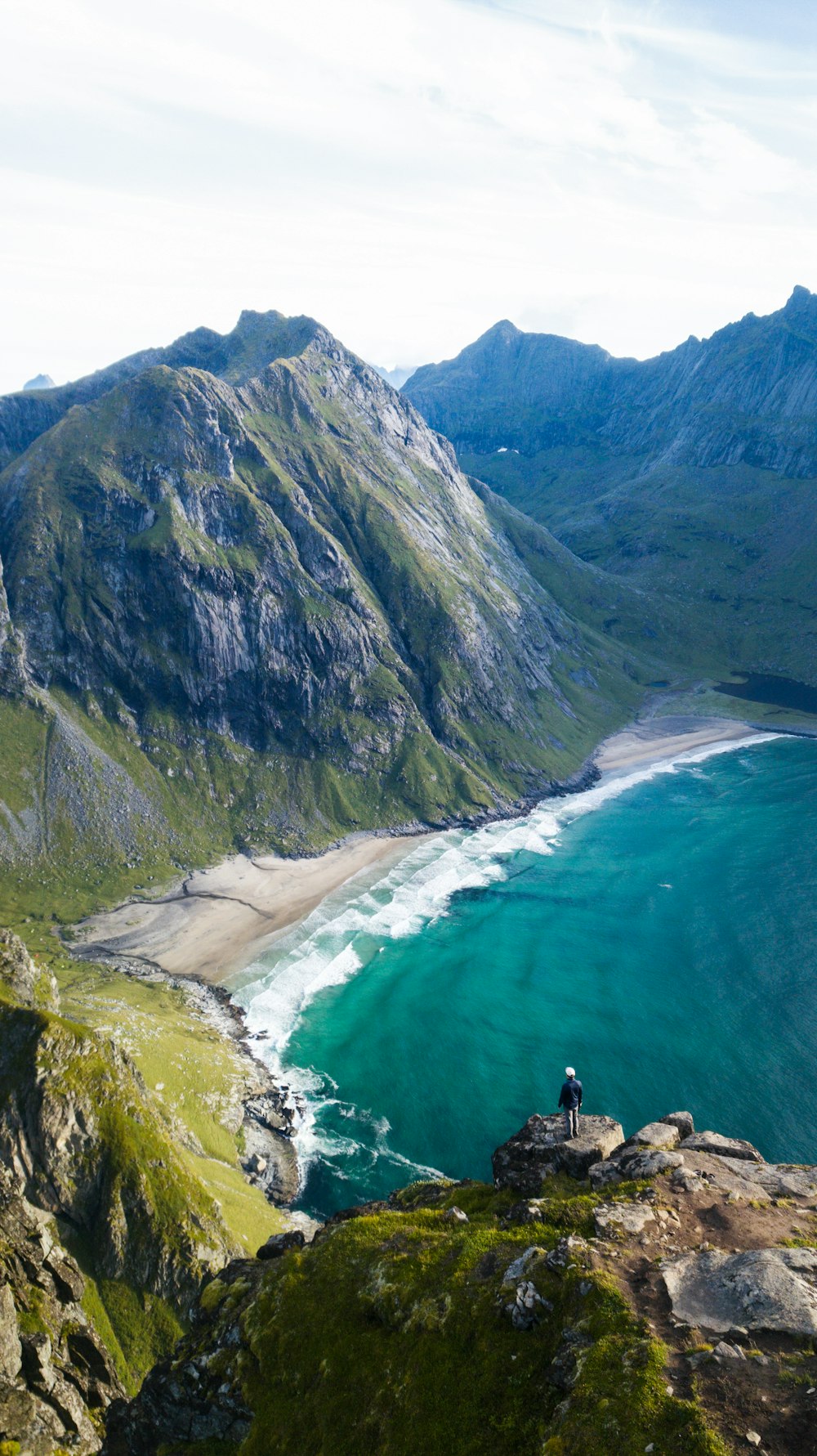 a person standing on a rocky cliff overlooking a body of water