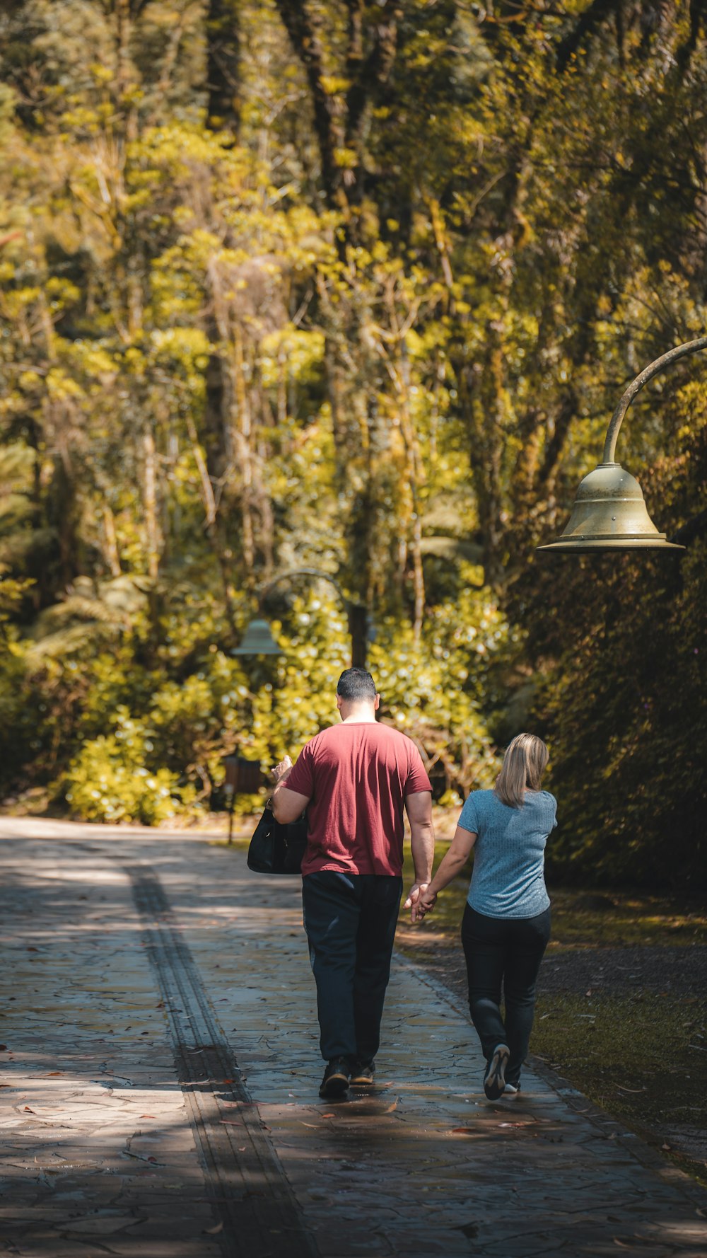 a man and woman walking on a path in a park