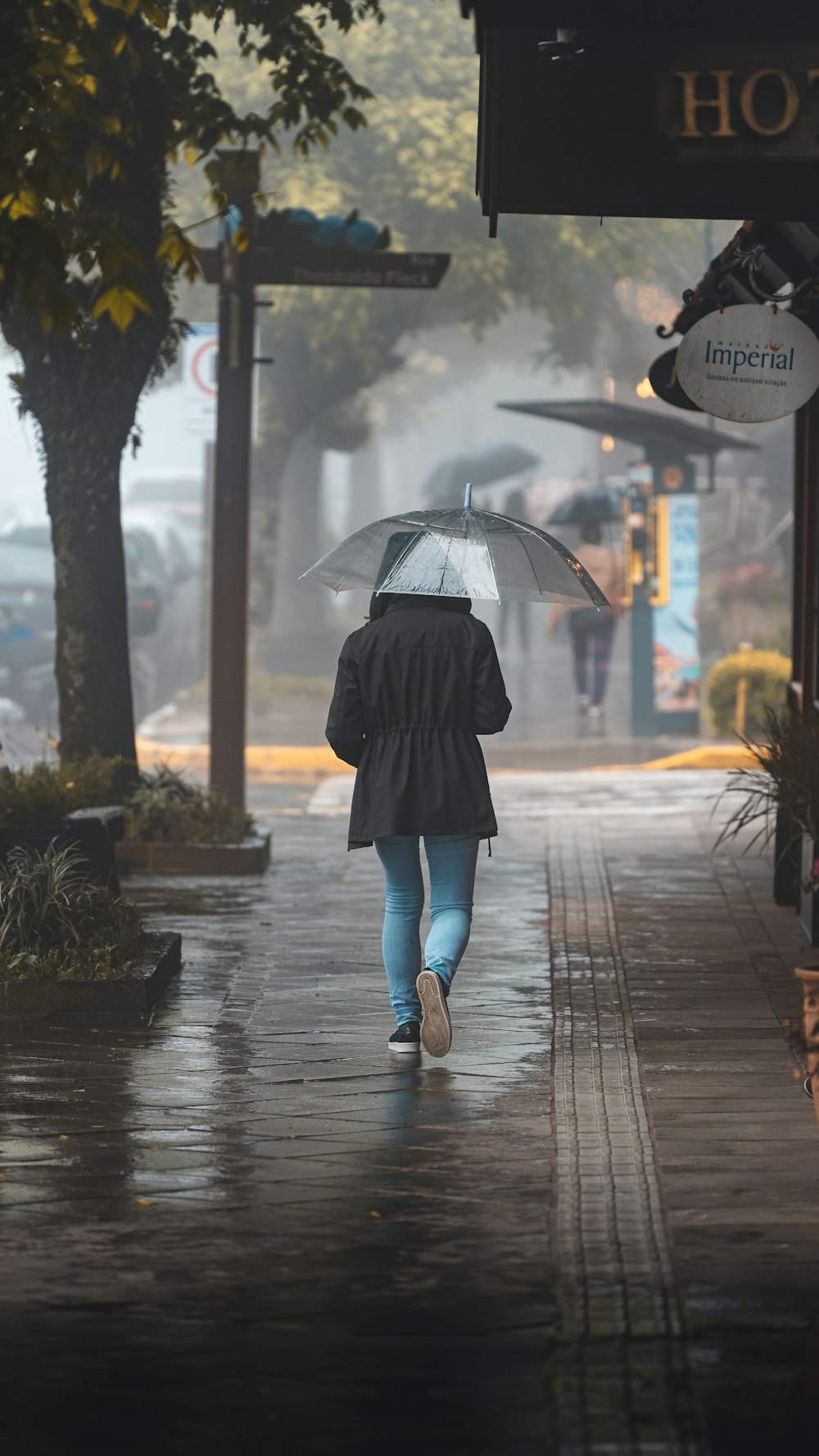 a person walking down a sidewalk with an umbrella