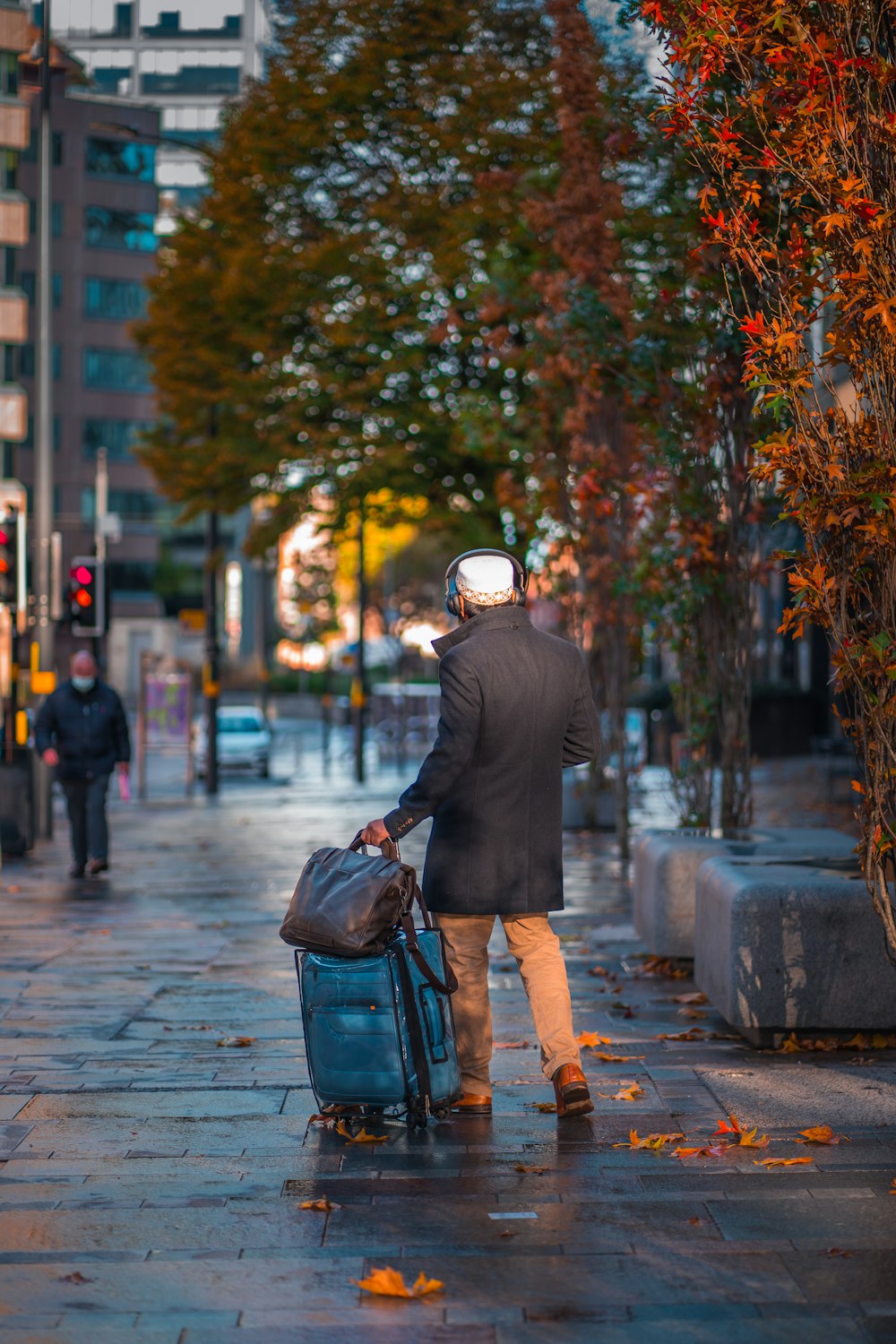 a person walking down a sidewalk with a suitcase