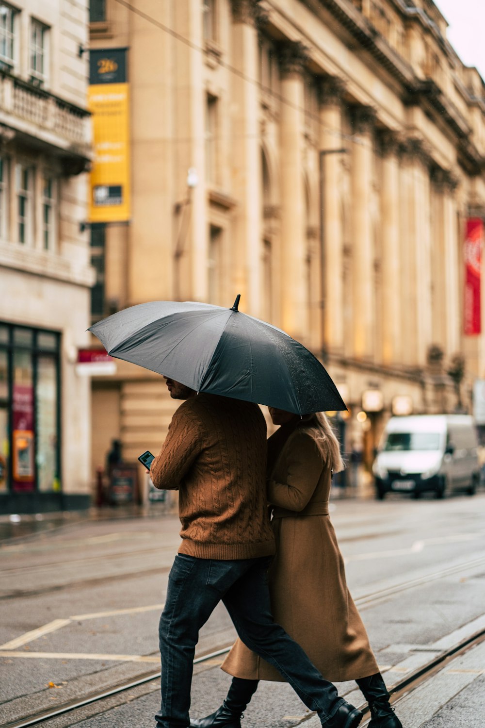 a couple walking down a street with an umbrella