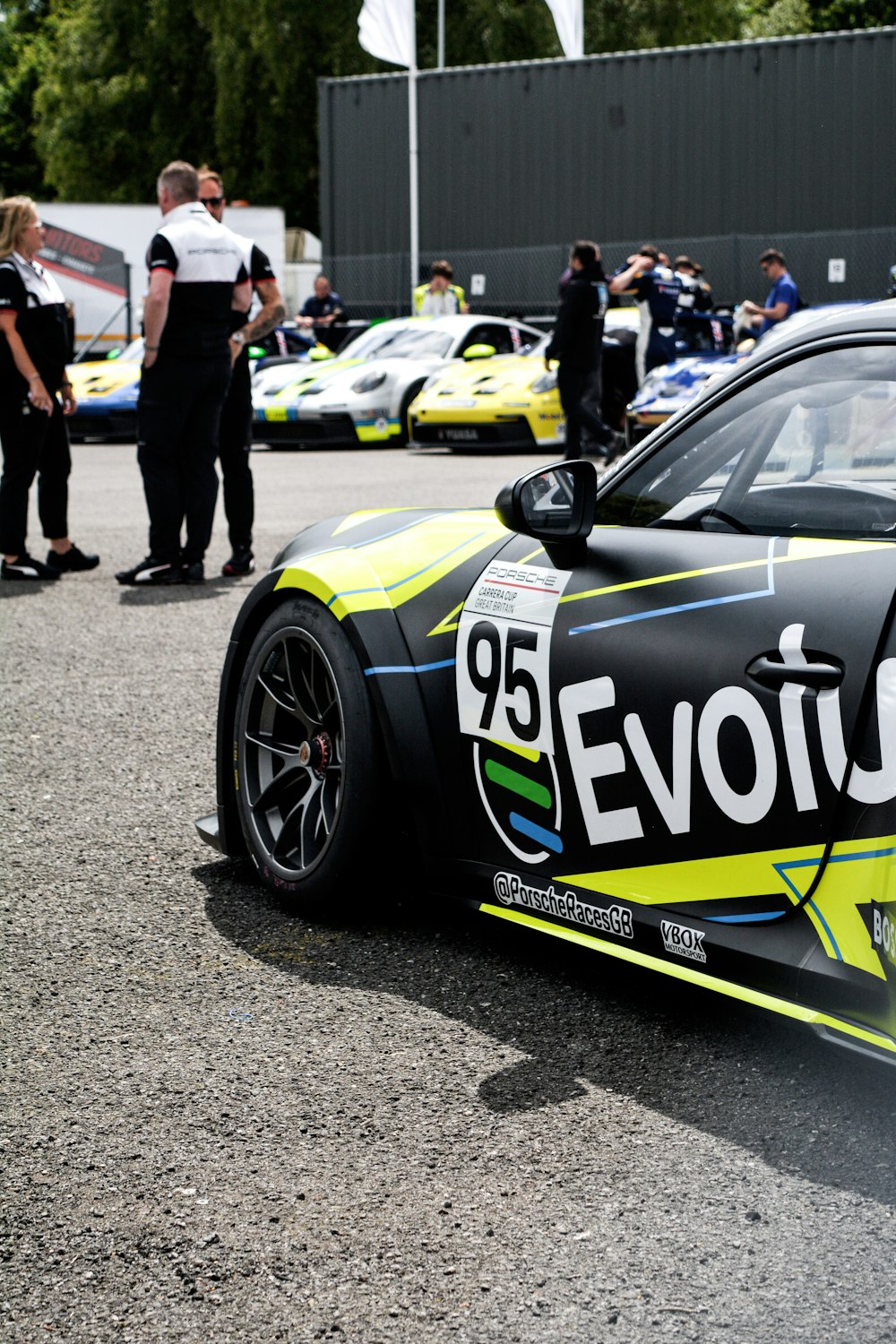 a group of people standing around a race car