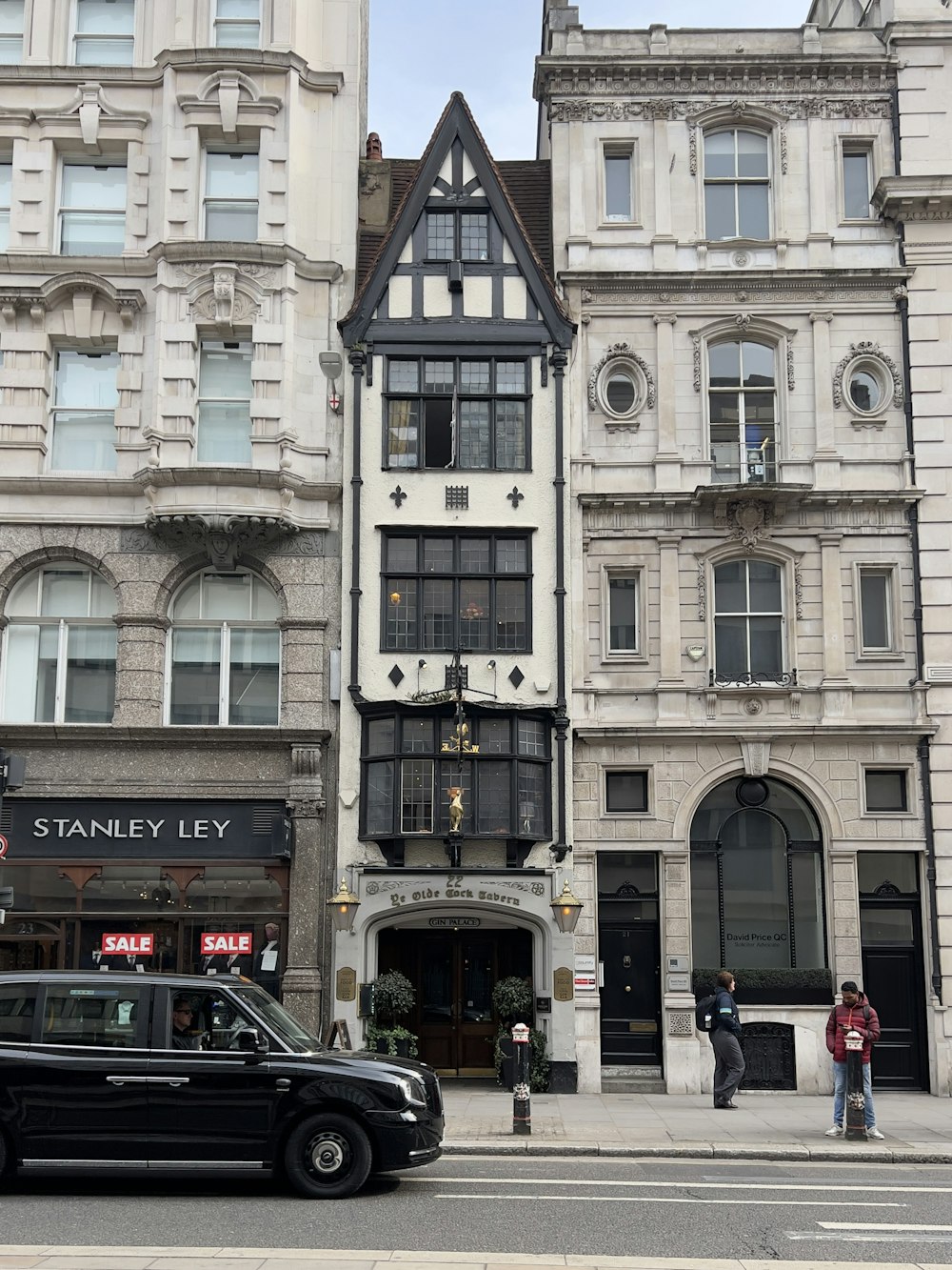 a black car parked in front of a building with a sign on it