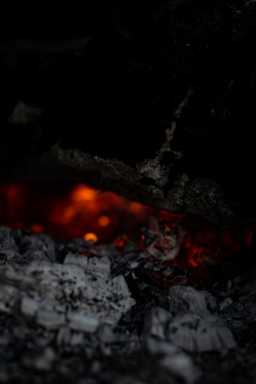 Close-up of glowing mesquite charcoal pieces with orange embers glowing softly in a dark setting