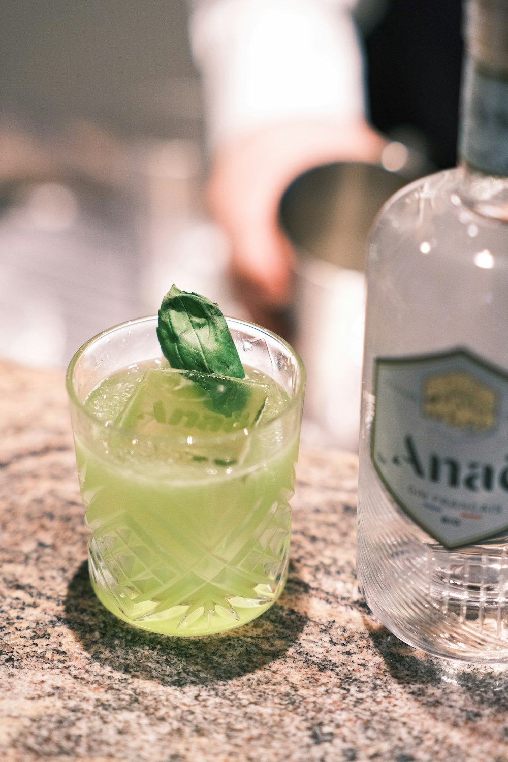 a glass of green liquid with a green leaf on top