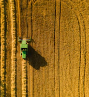 Side view of a compact robotic vehicle swiftly moving between rows of crops, illustrating maneuverability.