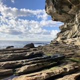 a rocky beach with a large body of water in the background