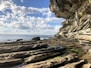 a rocky beach with a large body of water in the background