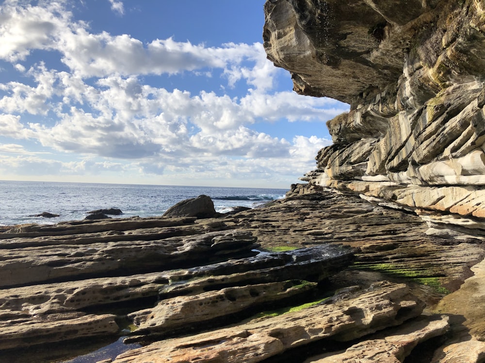 a rocky beach with a large body of water in the background