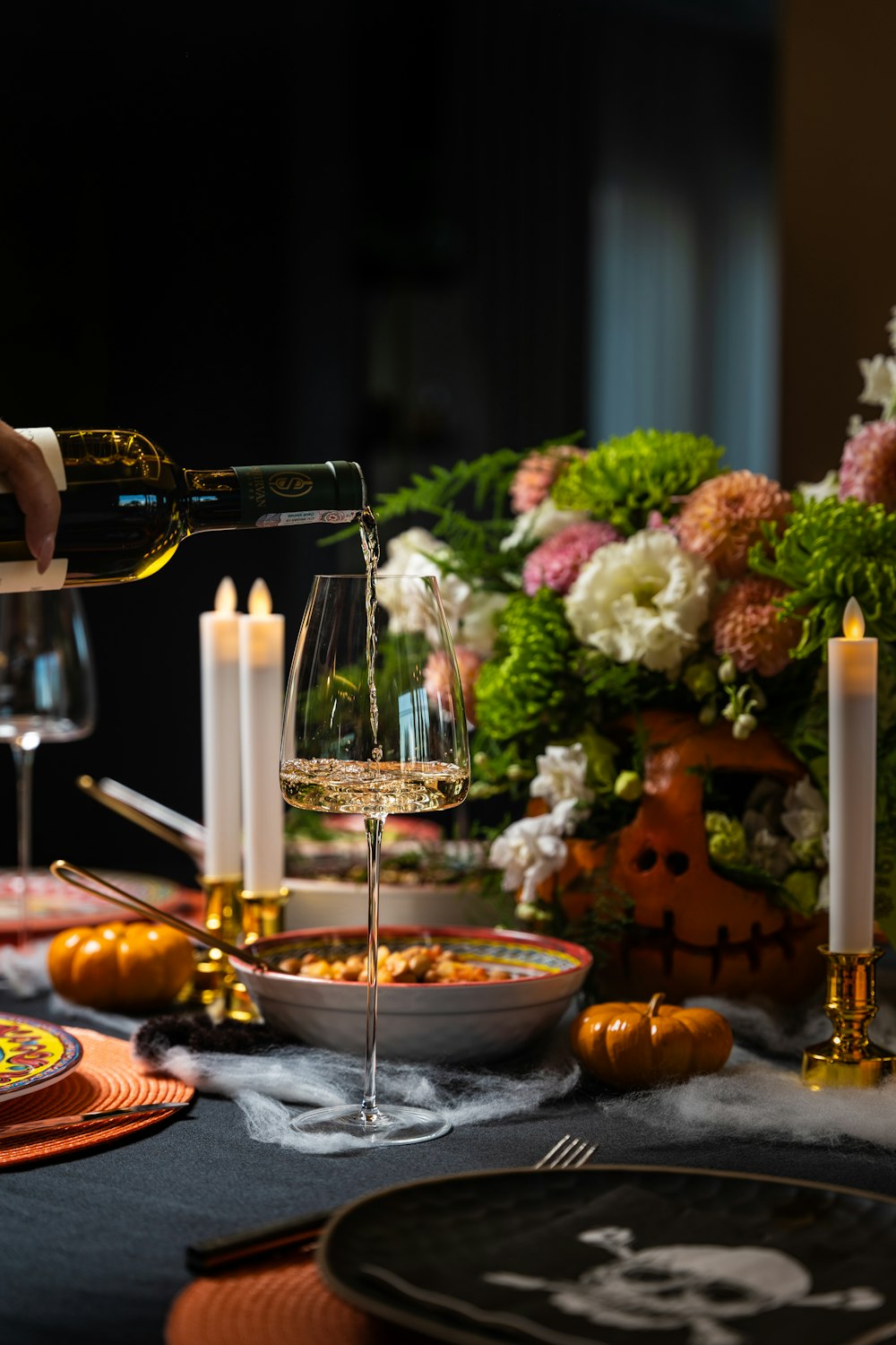 ein Tisch mit einem Weinglas und einer Schüssel mit Essen