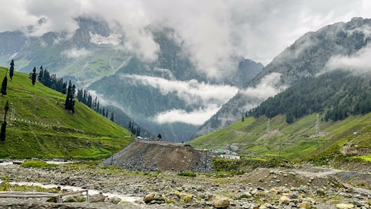 a valley with a few people walking on it and a mountain in the background