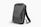 A sleek, black, hard-shell backpack with an ergonomic design. The front panel features distinct geometric patterns and a combination lock. The backpack has adjustable shoulder straps and a streamlined appearance, suitable for modern, urban settings.
