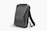 A sleek, black, hard-shell backpack with an ergonomic design. The front panel features distinct geometric patterns and a combination lock. The backpack has adjustable shoulder straps and a streamlined appearance, suitable for modern, urban settings.
