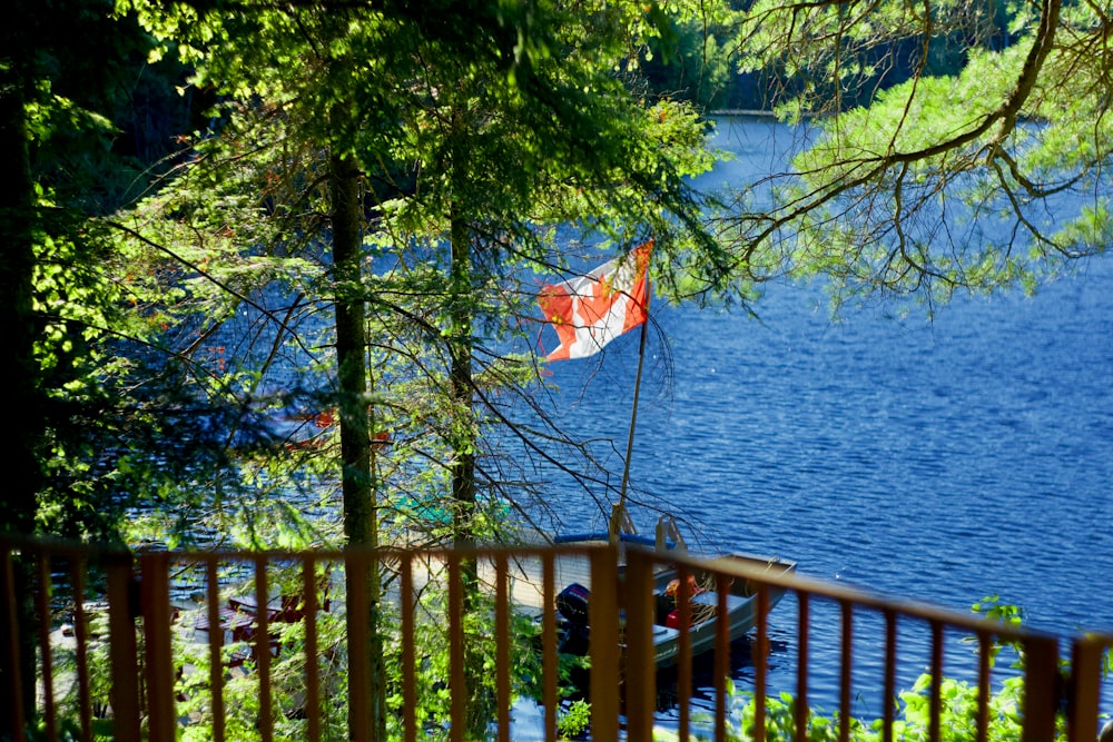 a flag on a railing by a body of water