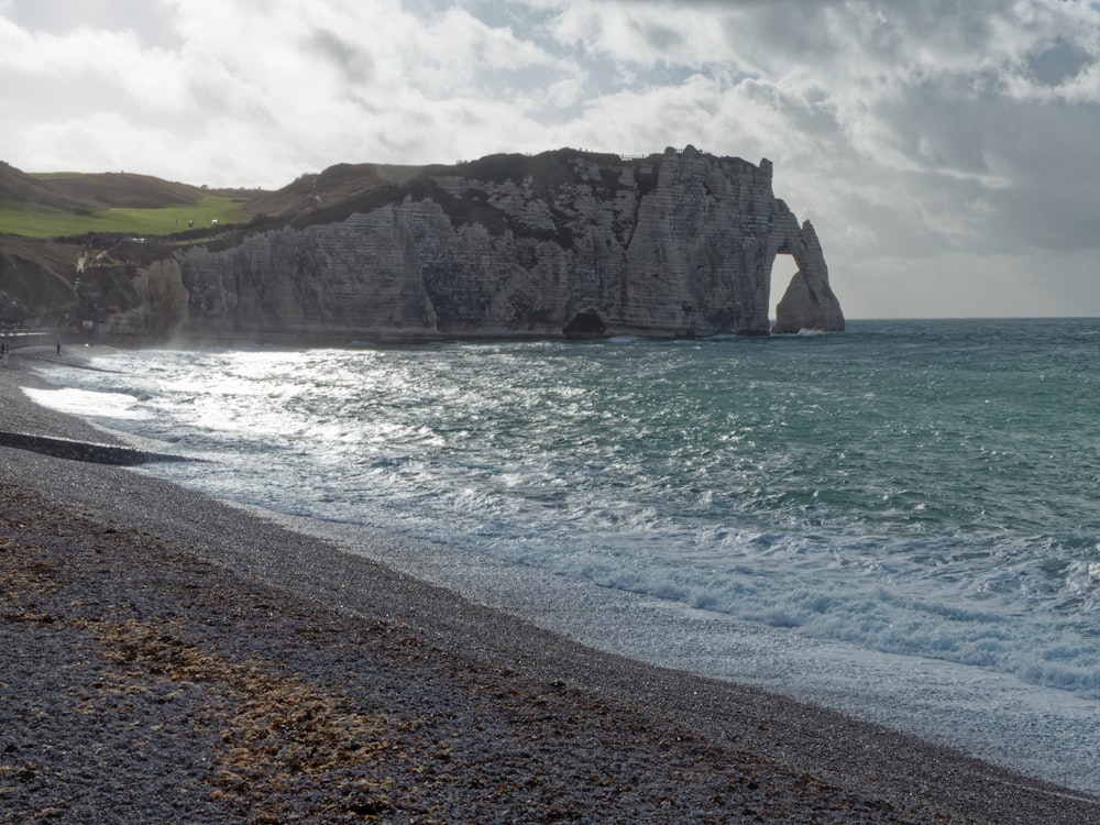 a beach with a cliff and water