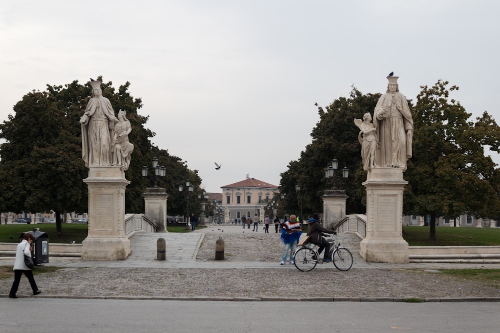 a group of people walking around a statue