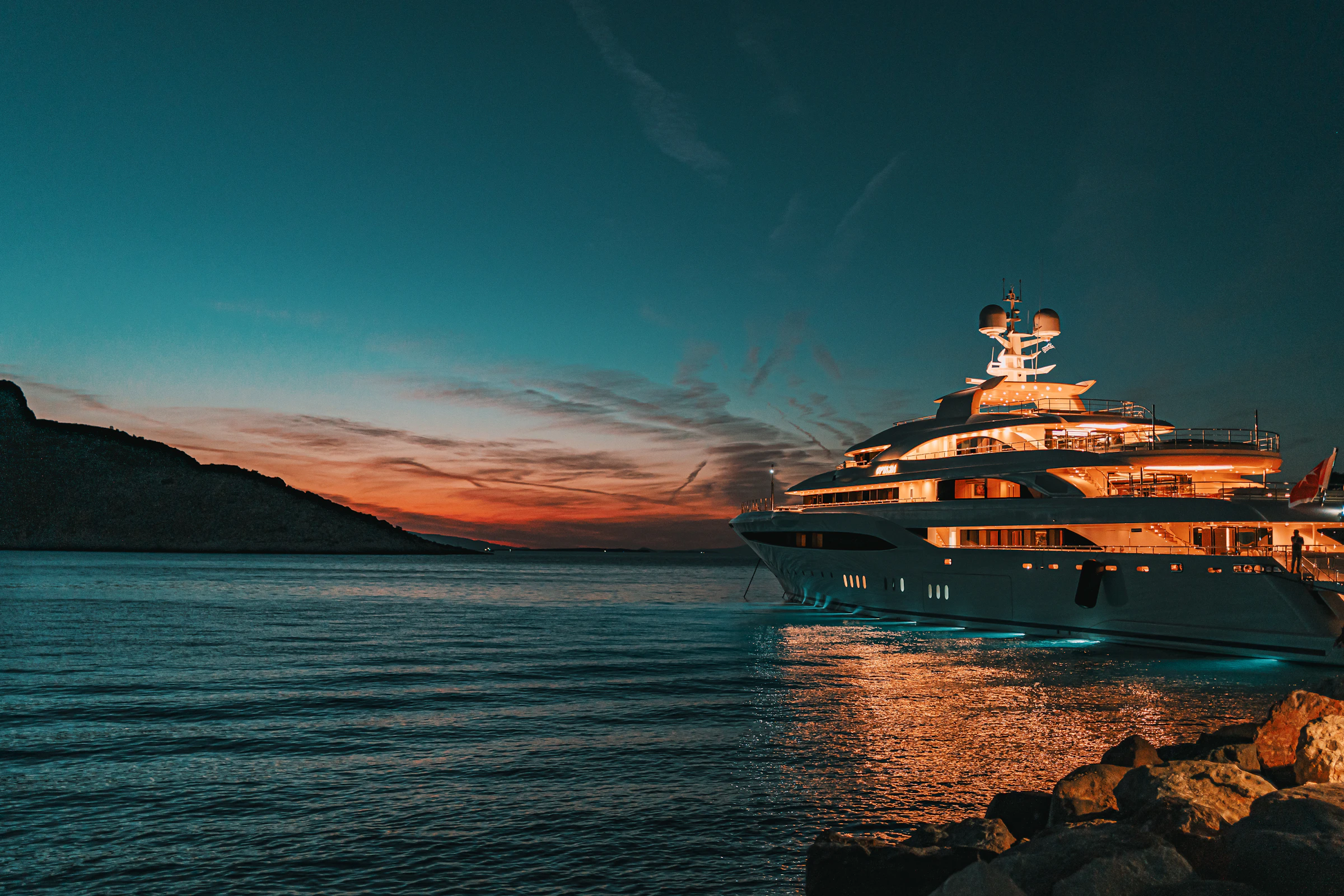 BLUEREEF — illuminated superyacht at anchor under a Mediterranean sunset