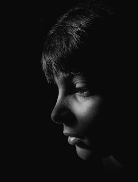 Modern portrait photo with strong black background and white accents.